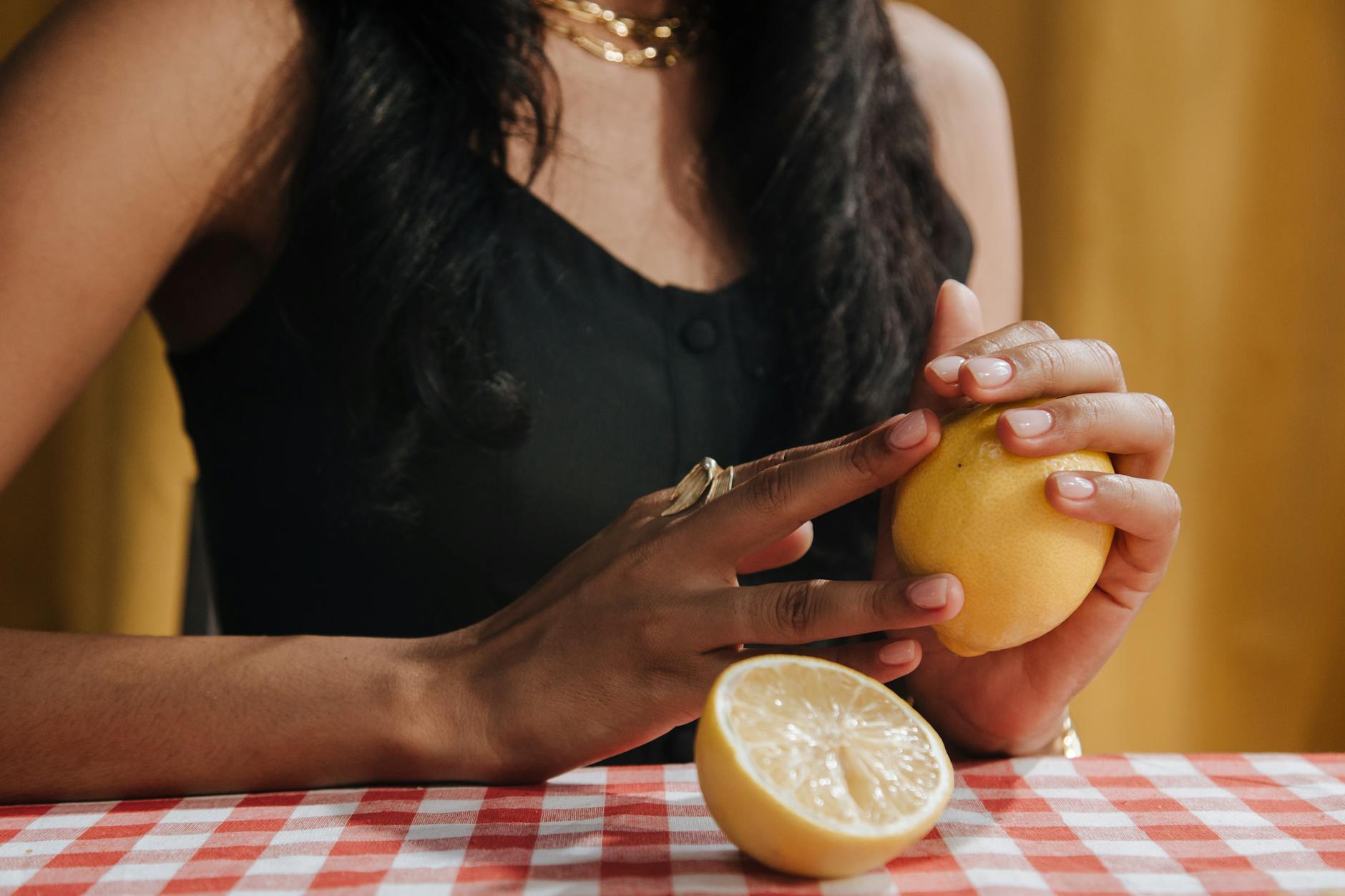 A blue vibrator surrounded by flowers and citrus slices on a bright yellow surface