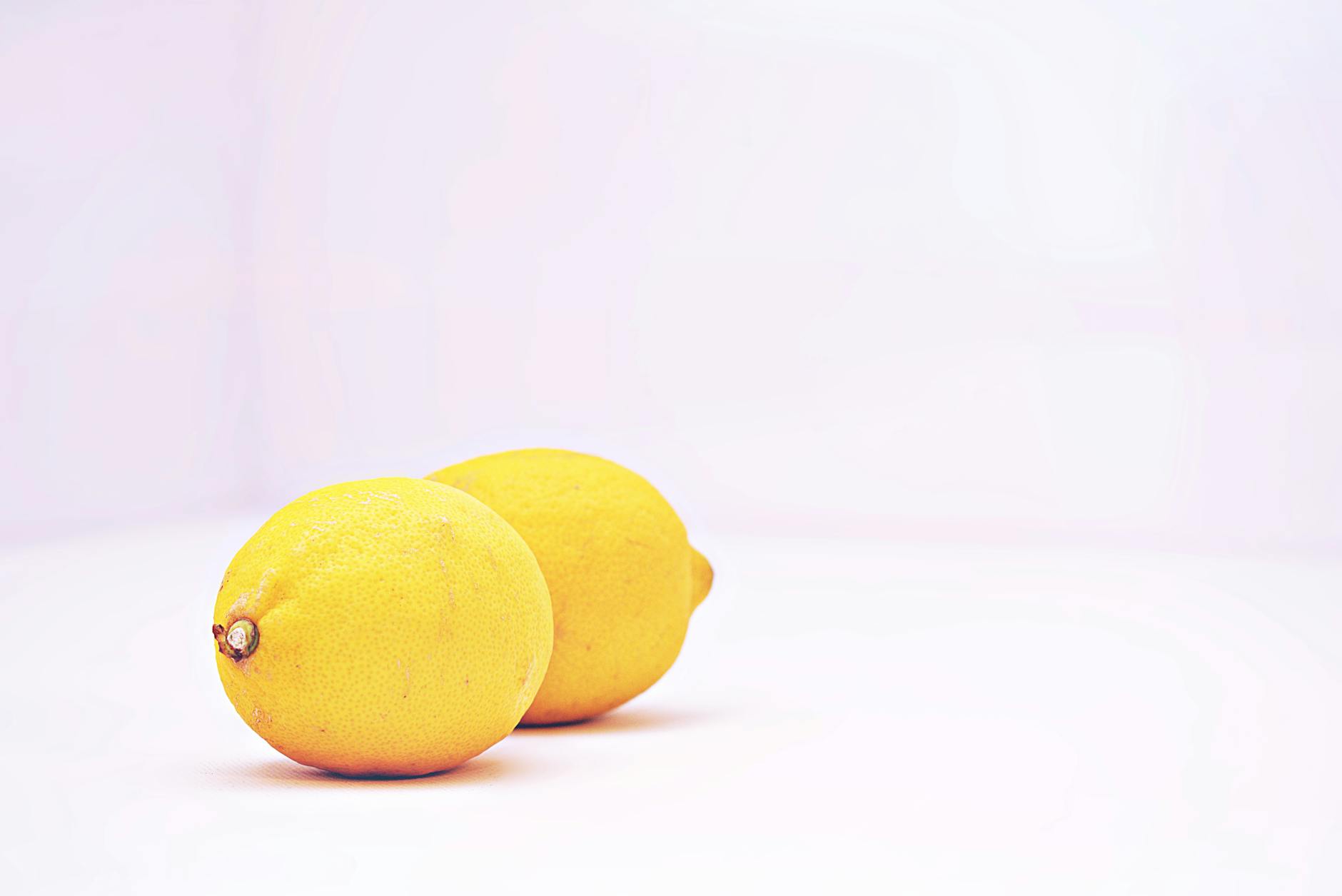 Two vibrant lemons on a white background, symbolizing fresh sensation and renewal.