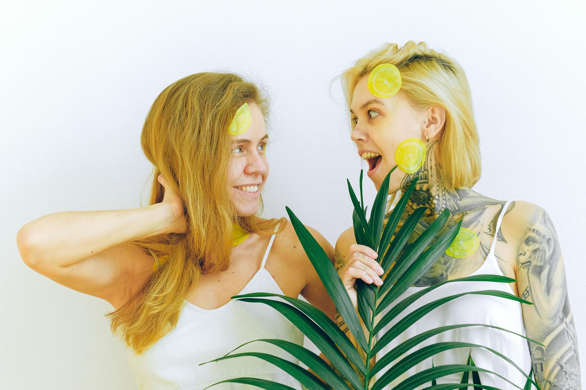 Two women with lemon slices together indoors, expressing joy and contentment