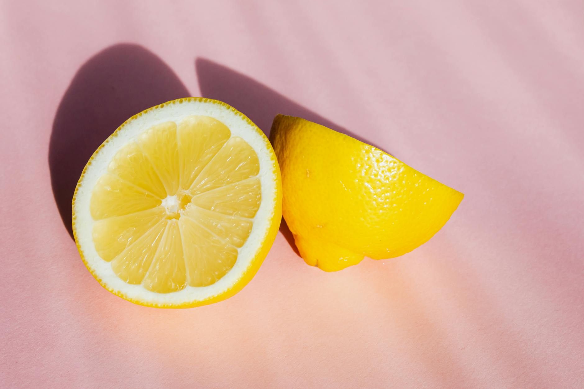 Teal lemon clitoral vibrator resting on white silk fabric