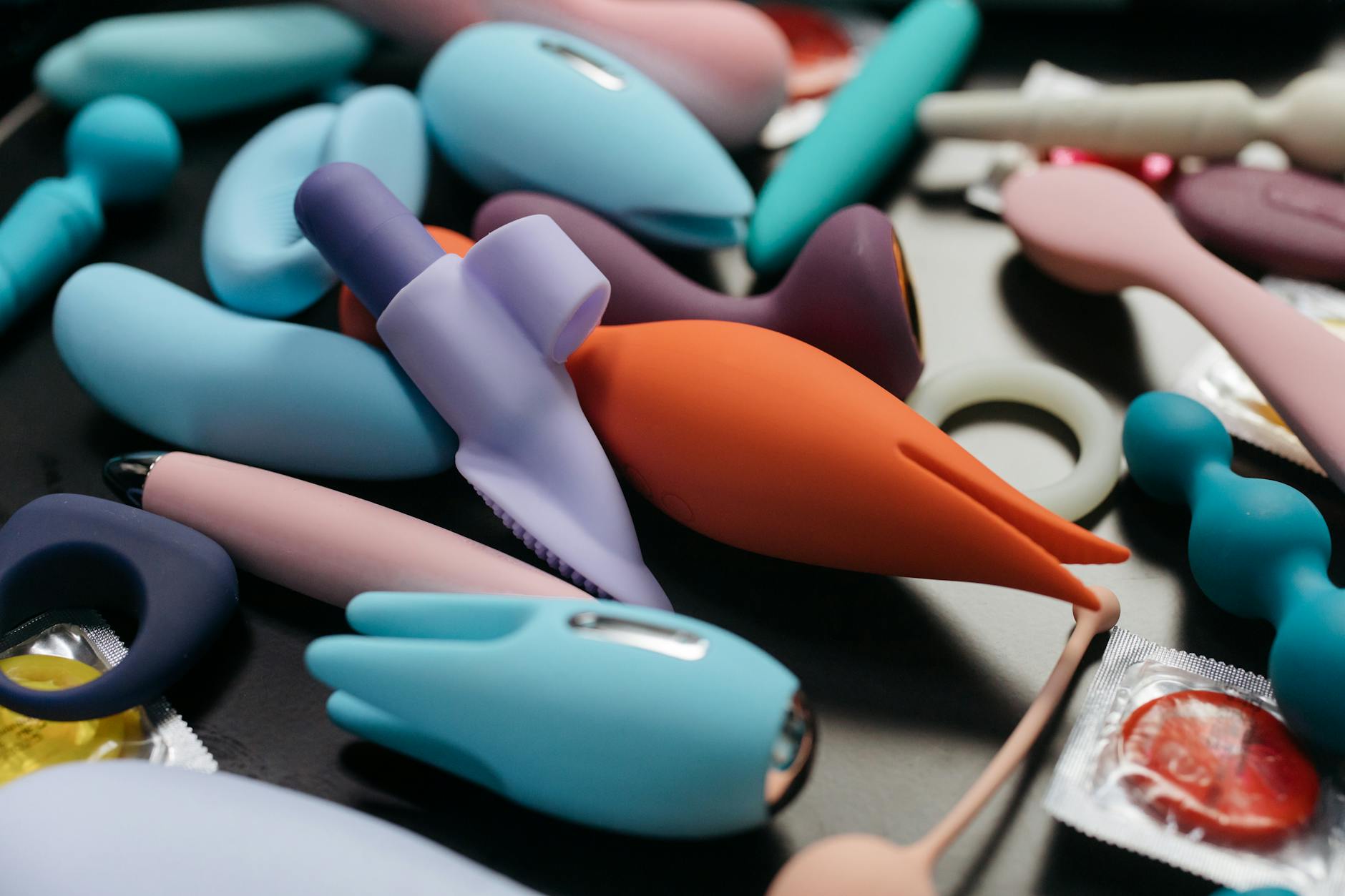 Hand holding a vibrator against a minimalistic purple backdrop, showcasing modern sensuality