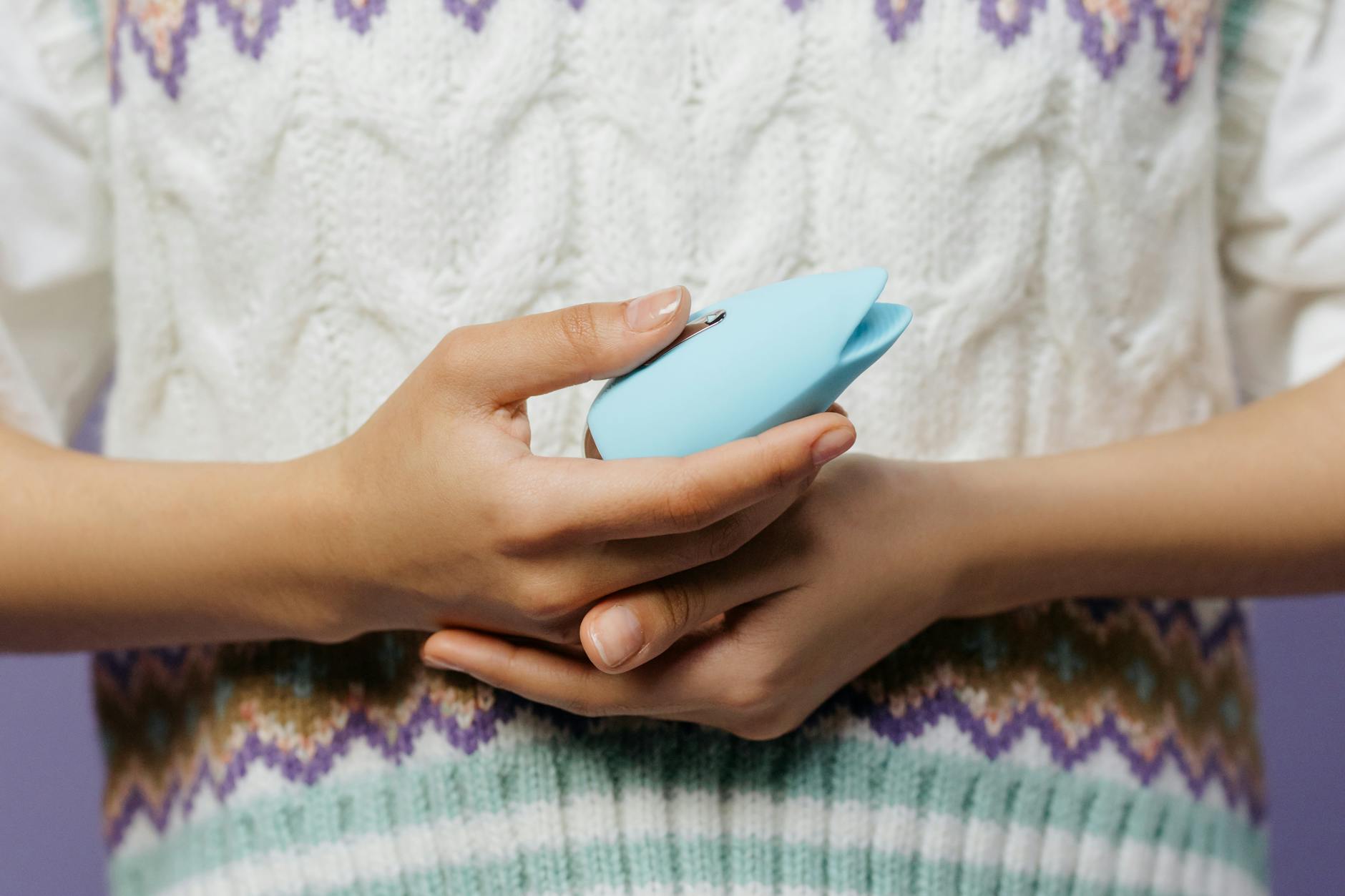 Woman holding multiple colorful silicone vibrators, considering which to choose