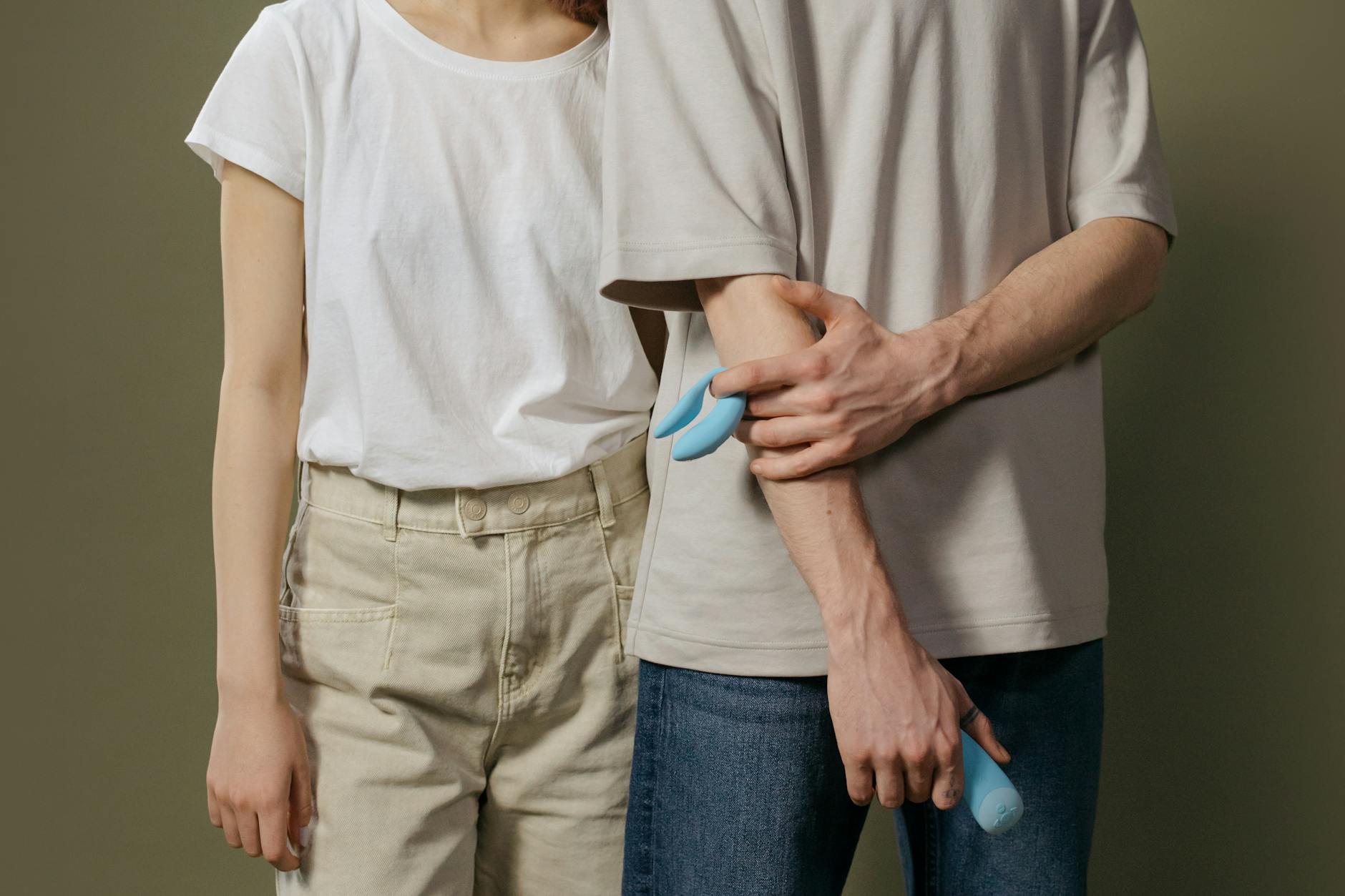 Blue silicone lemon vibrator held in hand against a purple background