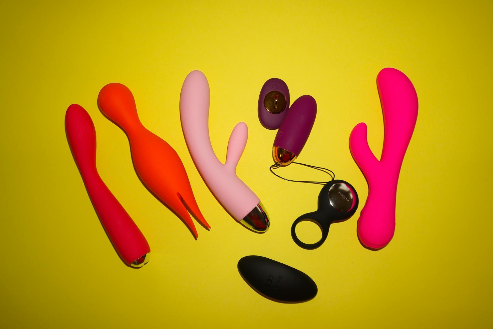 Woman holding a pink vibrator with art books in background