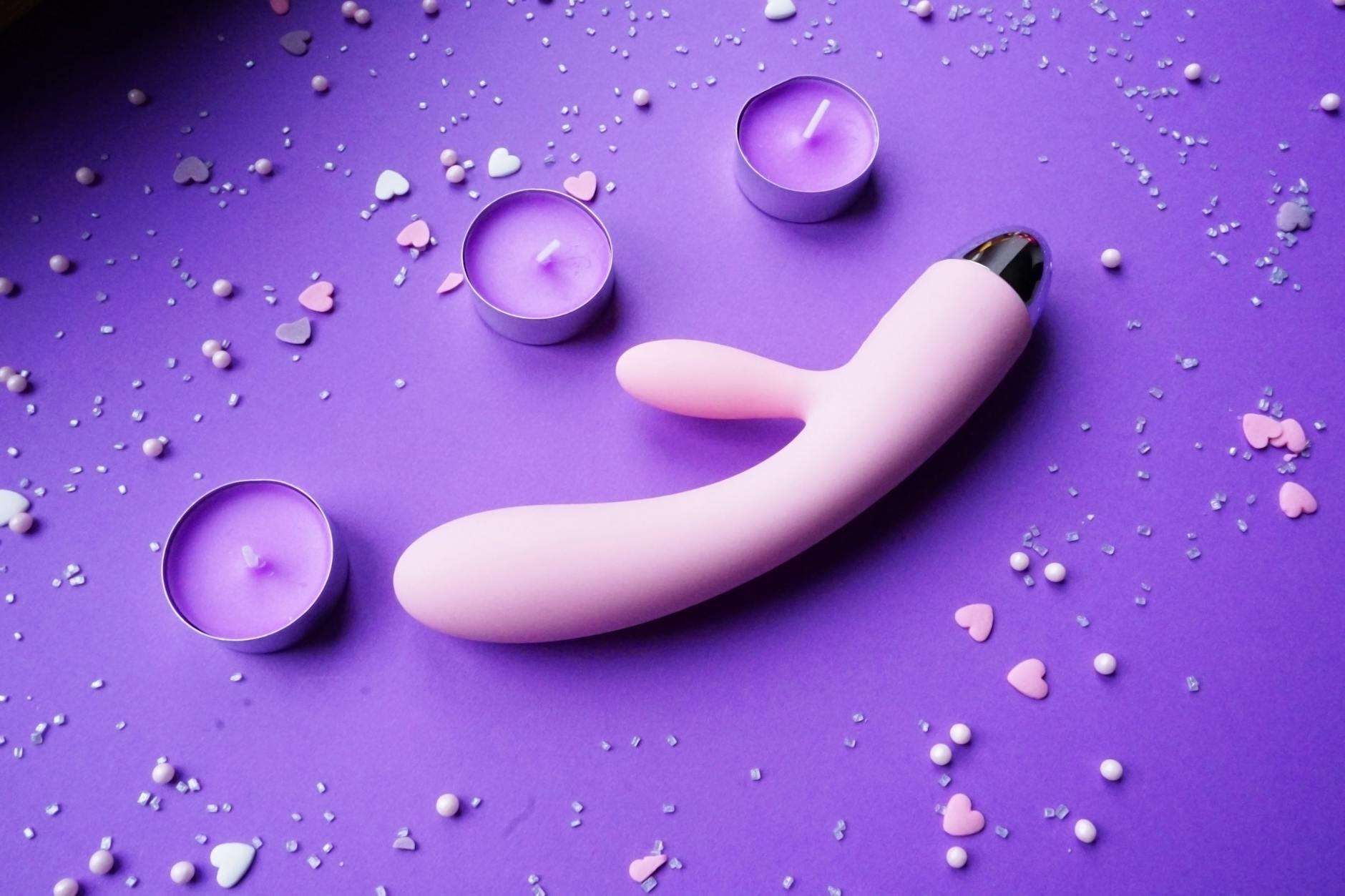 A young couple standing together indoors, exploring intimacy with shared pleasure devices