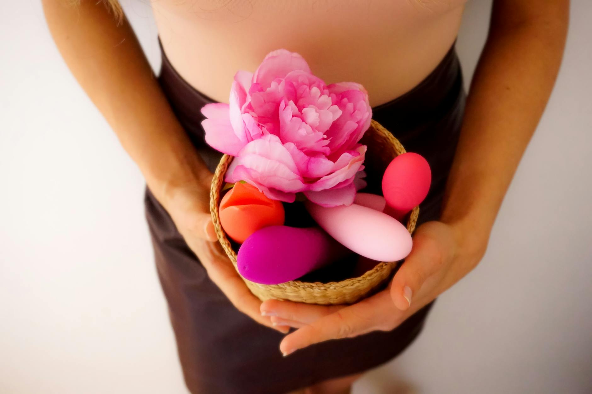 Woman holding two colorful vibrators, representing self-care during relationship challenges